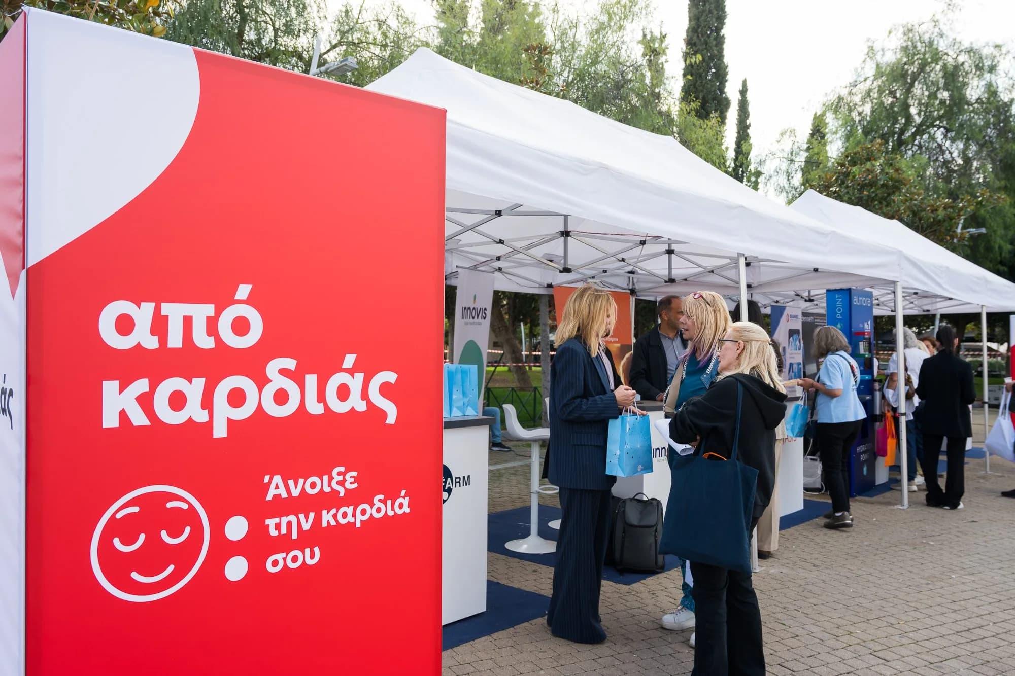 Πανό «από καρδιάς, Άνοιξε την καρδιά σου» μπροστά στα περίπτερα ενημέρωσης.